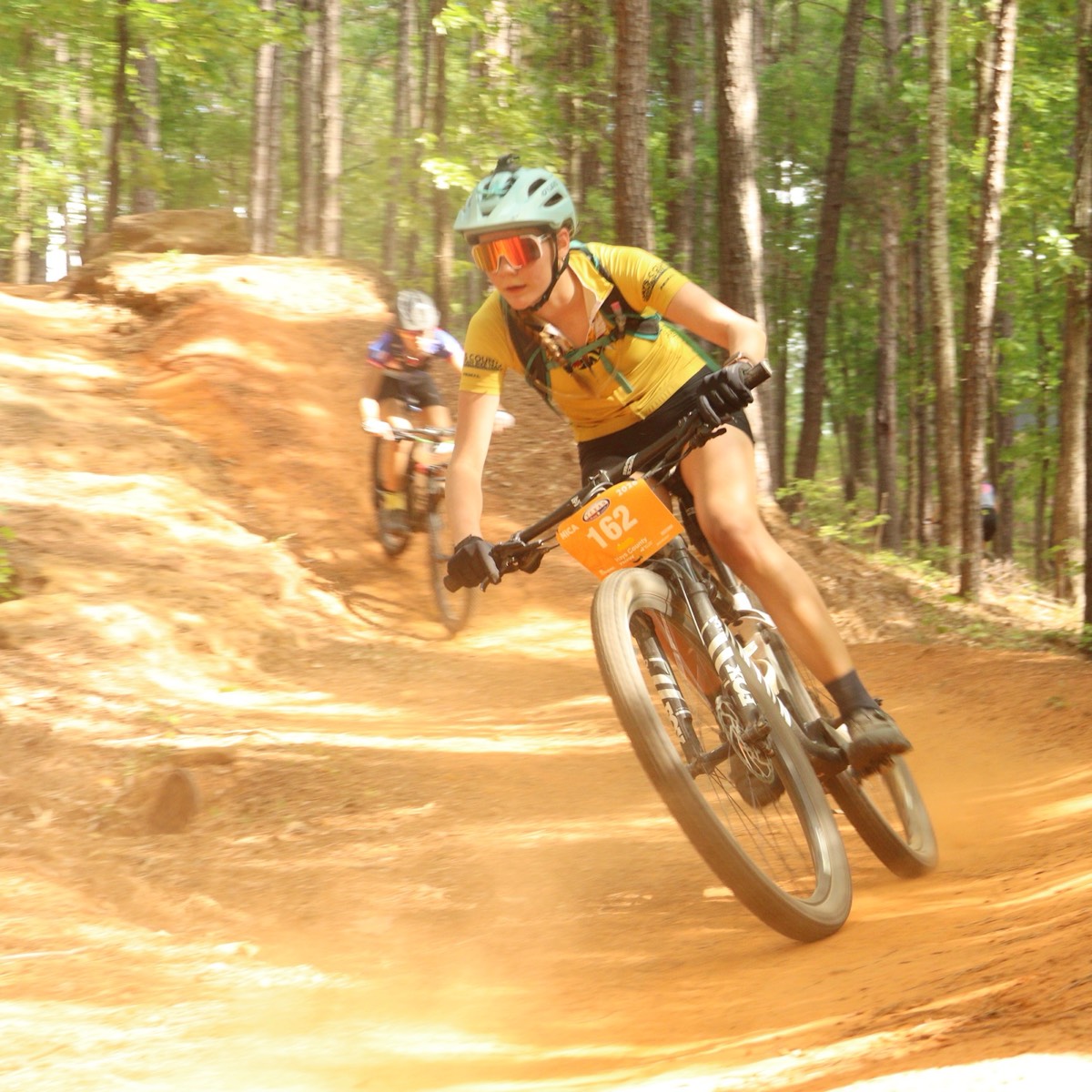 A Stingers rider railing a bermed corner during a cross-country race