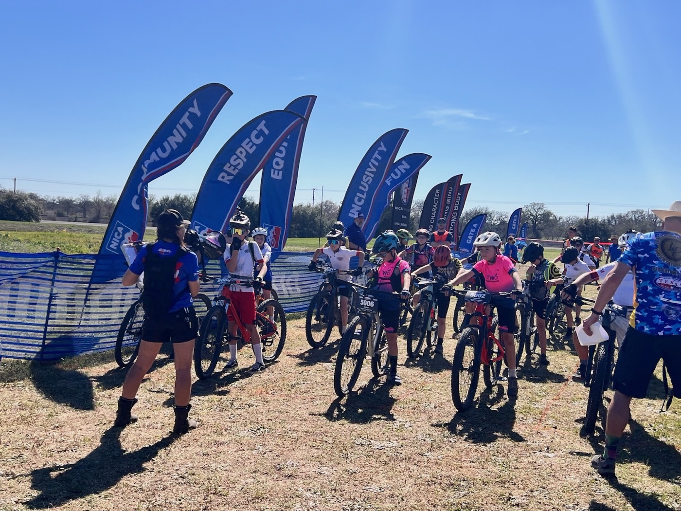 Stingers riders lined up at the start with NICA values banners behind them
